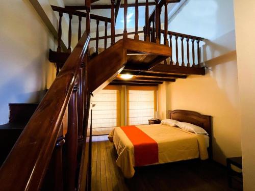 卡哈马卡Casa Bonita Colonial的一间卧室设有楼梯,卧室内设有一张床
