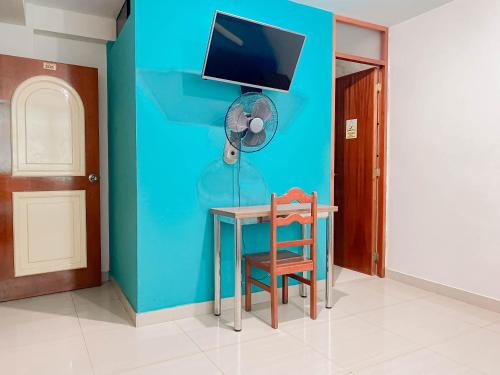 齐克拉约Hotel Señor de Sipán的客房设有桌子、风扇和椅子。