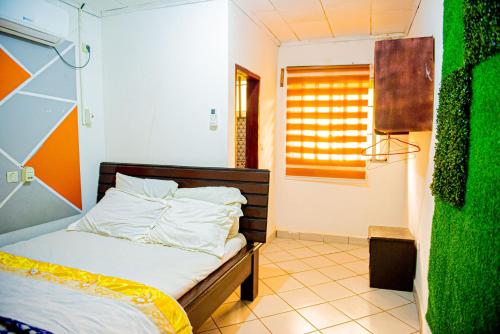 雅温得Appartement lumineux et paisible près centre Yaoundé的一间卧室设有一张床和一个窗口