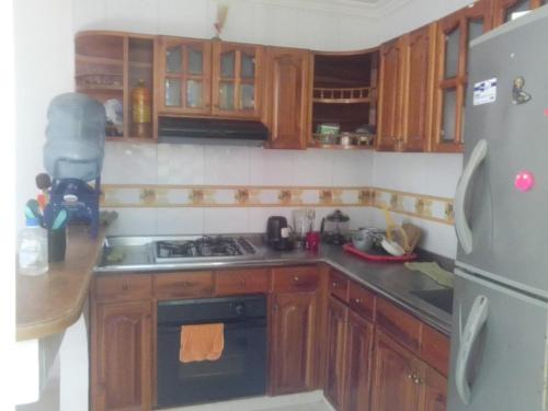 里考尔特Casa de Descanso的厨房配有木制橱柜、炉灶和冰箱。