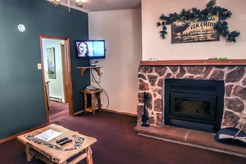 埃斯蒂斯帕克Timber Creek Chalets- 6 chalet的客厅设有壁炉和电视。