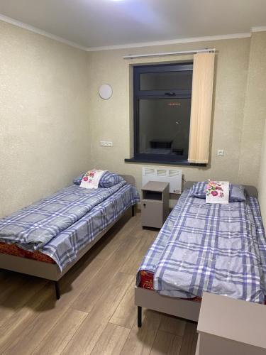 比什凯克Нарэл的一间卧室设有两张床、一个窗口和镜子