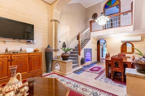马拉喀什16 Riads的一间配有电视和楼梯的大客厅