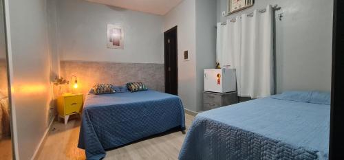 贝伦Hostel Cidade Velha的一间卧室设有两张床和黄色床头柜