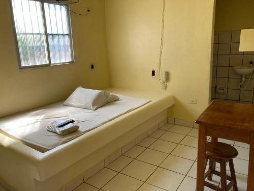 马塞约Pousada Caliente的一间卧室配有一张床、一个水槽和一张桌子