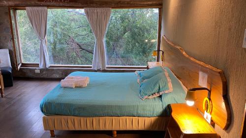 波特雷罗德洛斯弗内斯Sierras Oasis Apart的一间卧室设有一张床和一个大窗户