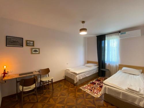叶海格纳佐尔Crossway Camping的客房设有两张床、一张桌子和一张桌子。