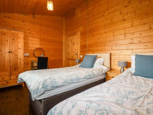 博德明Cherry Lodge的木墙客房的两张床