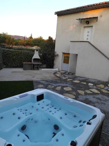 谢瓦布朗克La Remise de Guytou et Spa的房屋的院子内的热水浴池