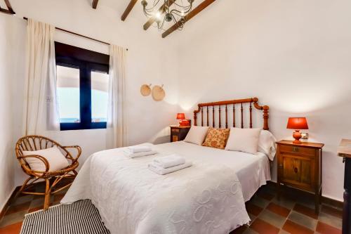 莫莱拉Villas Guzman - El Pino的卧室配有床、椅子和窗户。