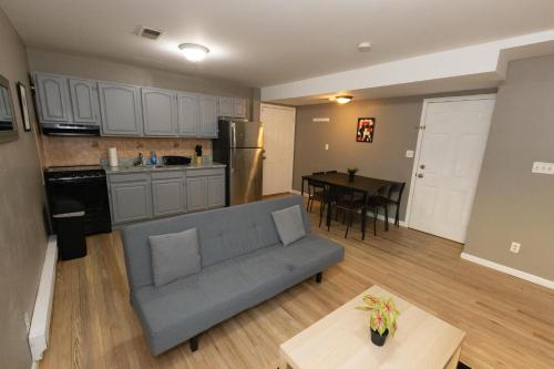 泽西市Pleasing 4- Bed Apartment Close to NYC的客厅以及带沙发和桌子的厨房。
