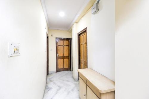 那格浦尔SPOT ON Hotel Sanskriti的走廊上设有白色的墙壁和木门