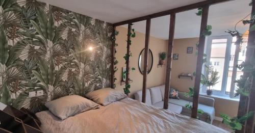 蓬塔穆松New jungle studio cœur de ville的一间卧室配有一张带热带壁纸的床