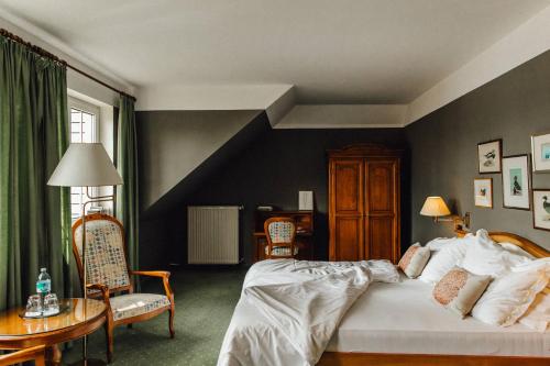 沃尔特湖畔佩莎赫莱纳别墅酒店的卧室配有一张床和一张桌子及椅子