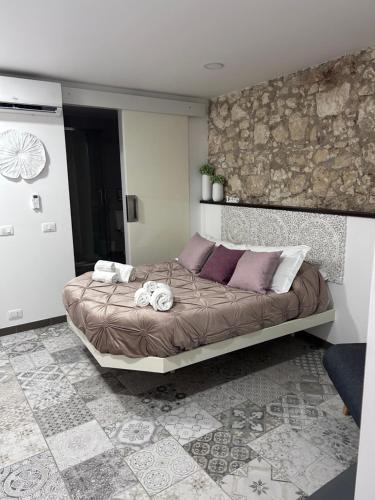 锡拉库扎Brimiky House的一间卧室配有一张带紫色枕头的大床