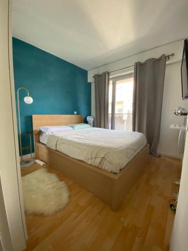 圣但尼Appartement cocooning, design, confort & Balcon的一间卧室设有一张床和蓝色的墙壁