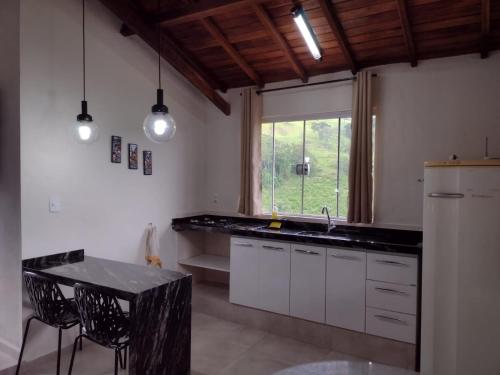 布埃诺布兰当Chalés Recanto das Flores的厨房配有水槽、桌子和窗户