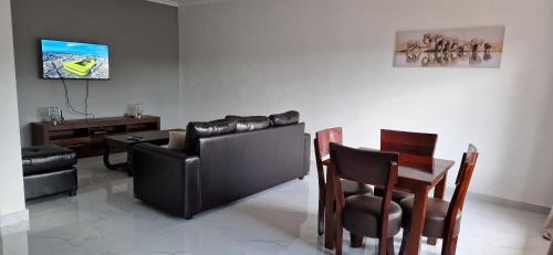 MuseleShalom Apartments Kalumbila的客厅配有沙发和桌椅