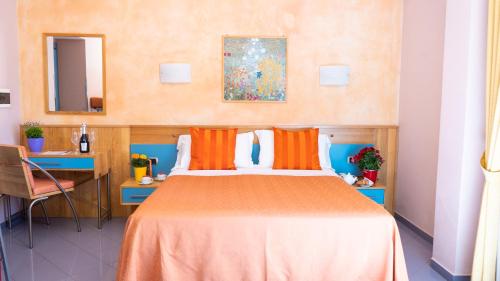 庞贝戴安娜酒店的一间卧室配有一张带橙色枕头的大床