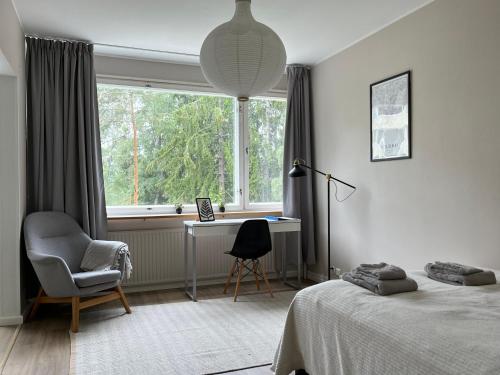 埃斯波Garden city studio的一间卧室配有一张床、一张书桌和一个窗户。