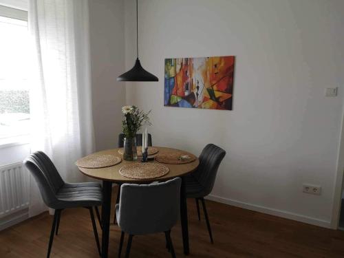因河畔布劳瑙Central stylish apartment的餐桌、椅子和墙上的绘画