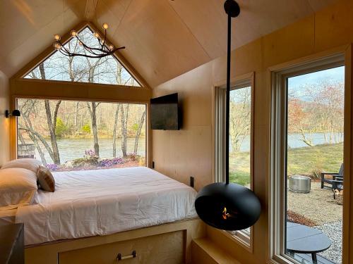 ArdenAsheville River Cabins的一间小房子里带窗户的卧室