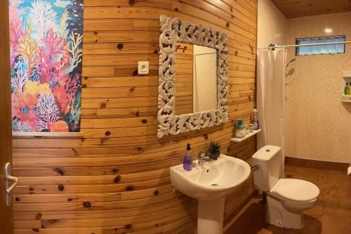 阿瓦托鲁Rangiroa Sunny House的浴室设有木墙、卫生间和水槽。