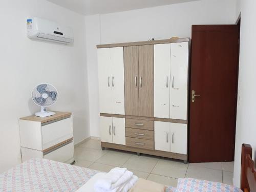 伊列乌斯Quarto e Sala - 200 M. Praia dos Milionários的一间卧室配有一张床、梳妆台和衣柜。