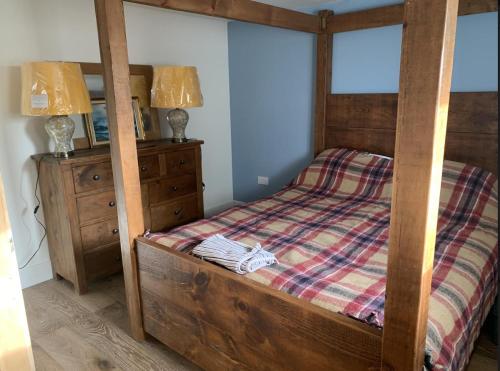 ArdminishISLE OF GIGHA FARM HOUSE的一间卧室配有一张木架床