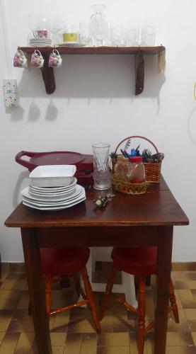 科伦巴LINDO APTO CENTRAL, MOBILIADO, AO LADO DO HOTEL NACIONAL CORUMBÁ -MS的一张木桌,上面有盘子和一个篮子