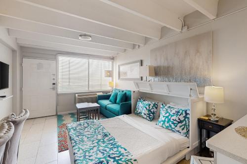 巴拿马城海滩Fontainebleau Terrace 223的一间小卧室,配有一张床和一张蓝色椅子