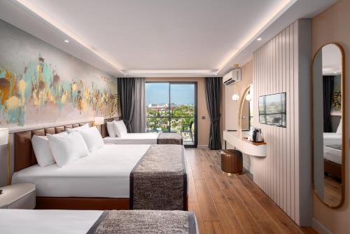 安塔利亚SEAPHORIA BEACH HOTEL & Spa - by Mir'Amor-Ultra All Inclusive的酒店客房设有两张床和窗户。