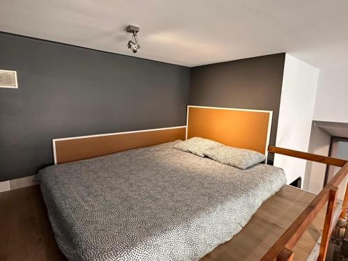 波兹南Apartamenty Gołębia-Genius的一间卧室设有一张床和灰色的墙壁