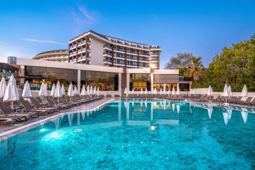 安塔利亚SEAPHORIA BEACH HOTEL & Spa - by Mir'Amor-Ultra All Inclusive的酒店前方的游泳池配有椅子和遮阳伞