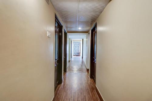 NalmathaOYO Flagship M H Grand的空的走廊,有长木地板和白色的墙壁