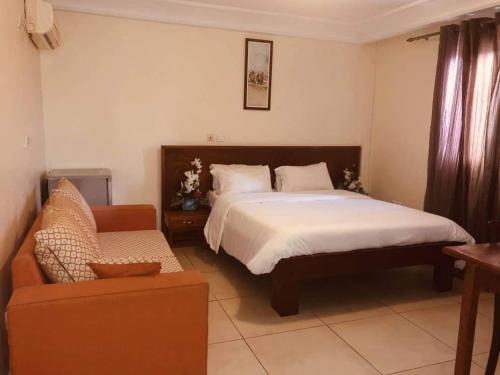 杜阿拉Hannatel Rooms Liberté的一间卧室配有一张大床和一张沙发