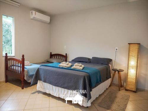 波梅罗迪Pomerânia Haus的一间卧室设有两张床和窗户。