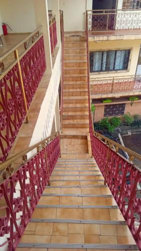 莫罗尼Moifaka Studio Hotel的通往一座红色金属栏杆的建筑的楼梯