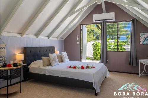 波拉波拉Matira Sunset House N659 DTO-MT的一间卧室,床上放着鲜花