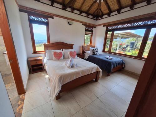莱瓦镇Casa Campestre Flores Amarillas的一间带两张床的卧室,位于带窗户的房间内