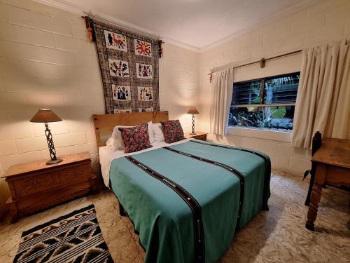危地马拉安地瓜Yellow House Hostel B&B的一间卧室设有一张大床和一个窗户。