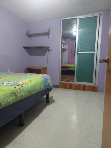 墨西哥城Habitación privada en Casa compartida, 4 adultos的一间卧室设有一张床和一个滑动玻璃门
