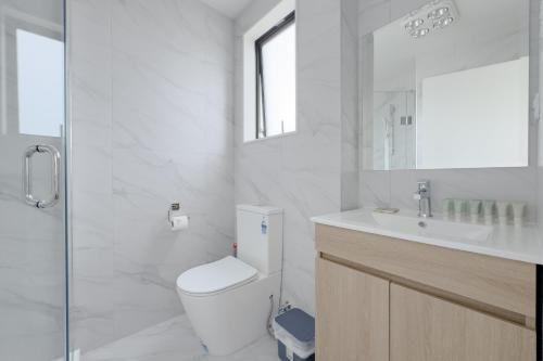 奥克兰Modern 3-bds townhouse in South Auckland的白色的浴室设有卫生间和水槽。