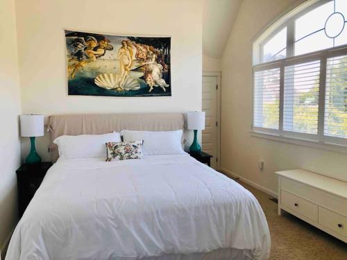 新港Seagrass Cottage at Beverly Beach的卧室配有一张白色床,墙上挂有绘画作品