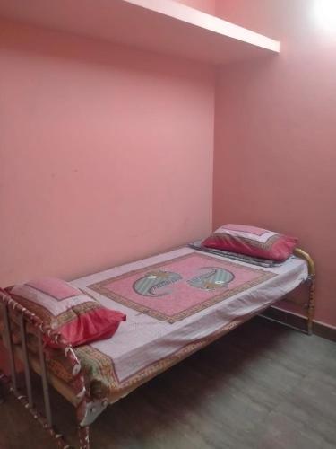 蒂鲁瓦纳马莱Shiva guest house的一间卧室配有两张带红色枕头的床