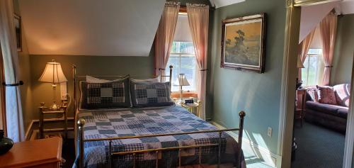 LornevilleAmherst Shore Country Inn的一间卧室设有一张床和一间客厅。