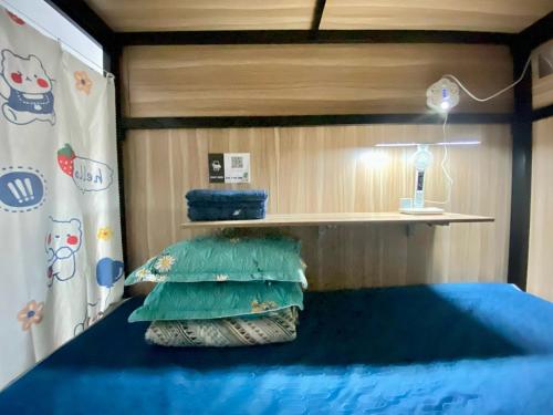胡志明市Start House CAPSULE 5 min walk to the Airport的一间卧室配有一张带蓝色床单和枕头的床。