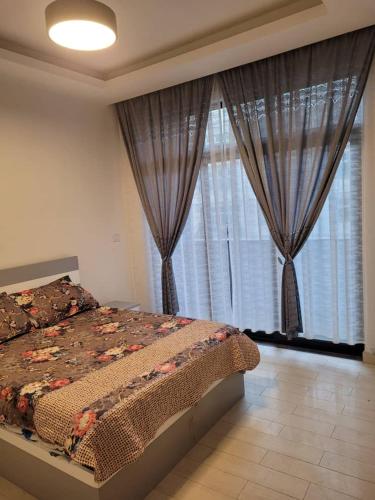 亚的斯亚贝巴Alsam Real Estate Gust House的一间卧室配有床和带窗帘的窗户