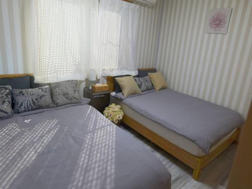 鉾田市Qiao No,105 - Vacation STAY 75661v的一间卧室设有两张床和窗户。