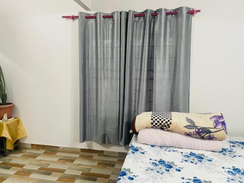 拜拉哈瓦Gautam HoUse的一间设有窗帘和一张带枕头的床的房间